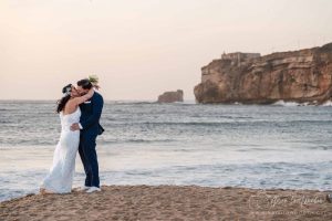 Casal de noivos na praia de Nazaré ao pôr do sol